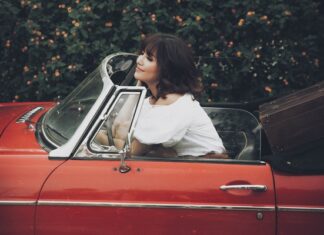 Bich Phuong showcases her alluring shoulders next to a classic convertible car